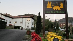 A sign for "Casa de la Montaña" with a mountain and sun illustration. - Casa de la Montaña (Onis)