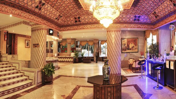 Un lobby imponente con columnas ornamentadas, un bar con piano y una zona de bar.