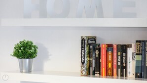 Uma estante com livros e um vaso de planta.