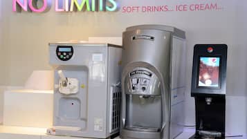 A water dispenser with a digital screen, a coffee machine, and a soft drink dispenser.