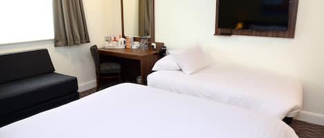 A hotel room with two beds, a desk with a mirror, a chair, and a television.