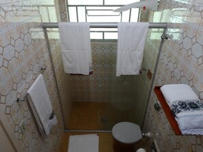 A small bathroom with a shower, toilet, and a towel rack with two towels.