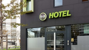 A modern hotel building with a glass facade, a prominent B&B Hotels logo, and a clear entrance.