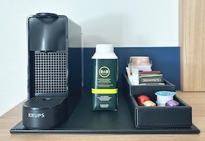 A black Krups humidifier, a B&B Hotel water bottle, and a set of toiletries in a black case.