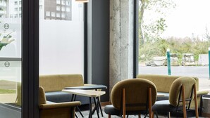 A modern interior with a sofa, chairs, a small table, and pendant lighting.