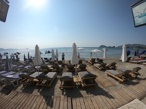 En la playa, camastros, sombrillas y bar en la playa 