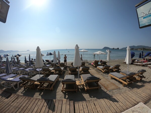 A beachside deck with sun loungers and umbrellas, overlooking the sea. - Casa Del Mar (Zakynthos)
