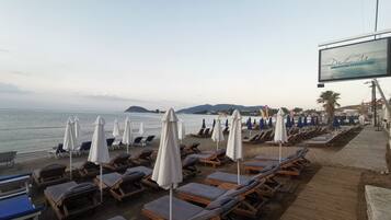 På stranden, solstolar, parasoller och strandbarer