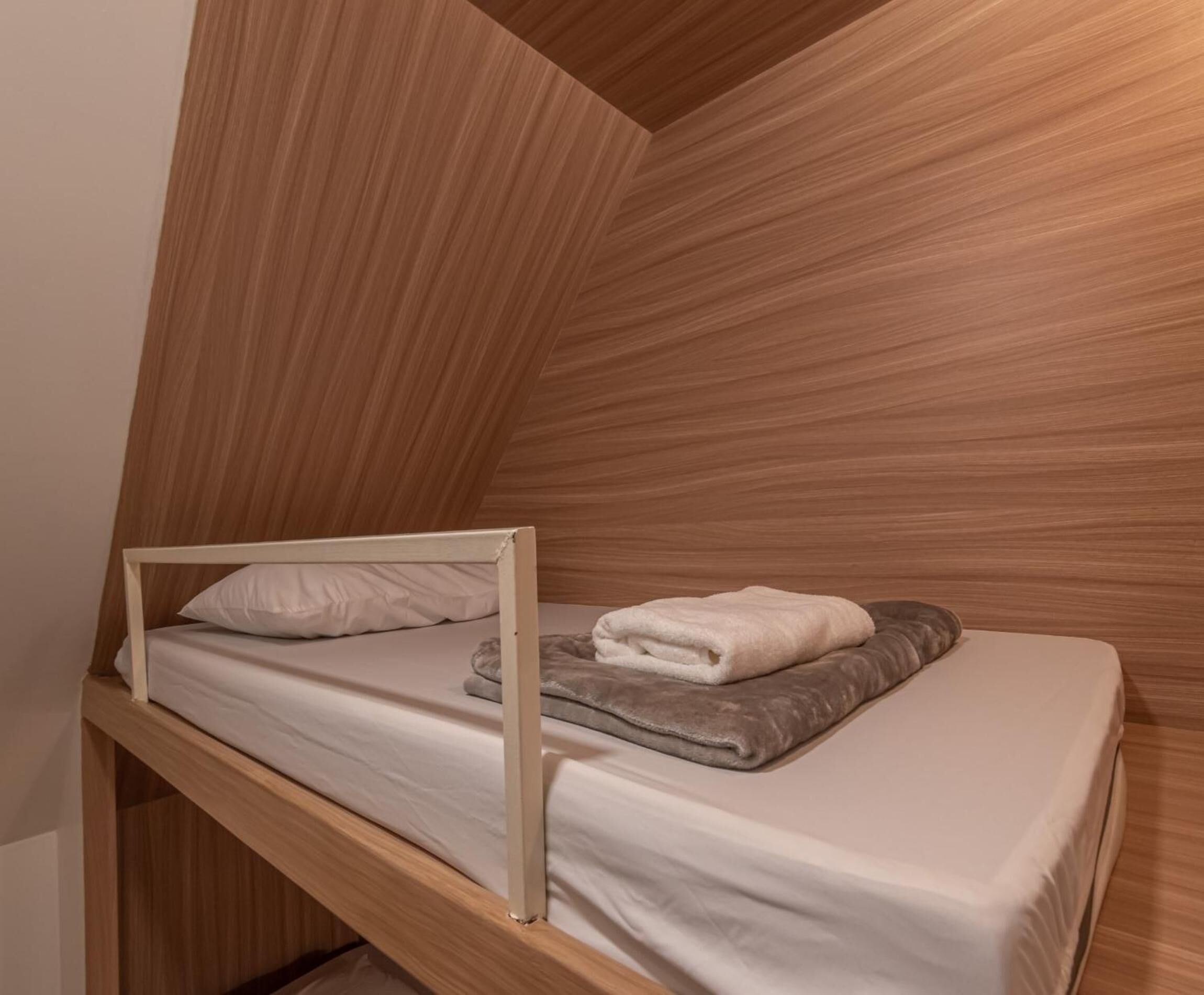 Una cama litera con estructura de madera y un colchón.