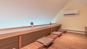 A modern room with a wooden bench, a small plant, and a white air conditioning unit on the wall. - The Victory View - Hostel - Adults only (Bangkok)