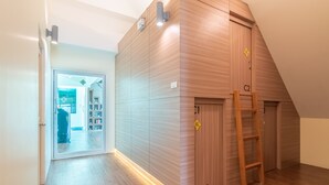 A room with a wooden wardrobe, a ladder, and a door marked 'C2'. - The Victory View - Hostel - Adults only (Bangkok)