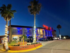A hotel with a sign reading 'Southwind Inn' and a parking lot with several cars. - Southwind Inn (Port Isabel)