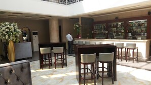 A hotel lobby with a bar area, seating arrangements, and a decorative vase. - Hotel Amaritsah (Brazzaville)