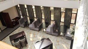 A modern indoor seating area with high ceilings, marble flooring, and large windows. - Hotel Amaritsah (Brazzaville)