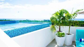 Una piscina al aire libre, sillones reclinables de piscina