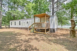 Standalone cabin with a covered porch surrounded by a natural setting.
