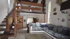 A loft-style room with a built-in staircase, a patterned sofa, and a decorative wall.