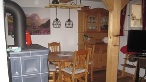 A cozy kitchen with a built-in stove, wooden cabinets, and a dining area with chairs. - Ferienhaus Becker (Roedental)