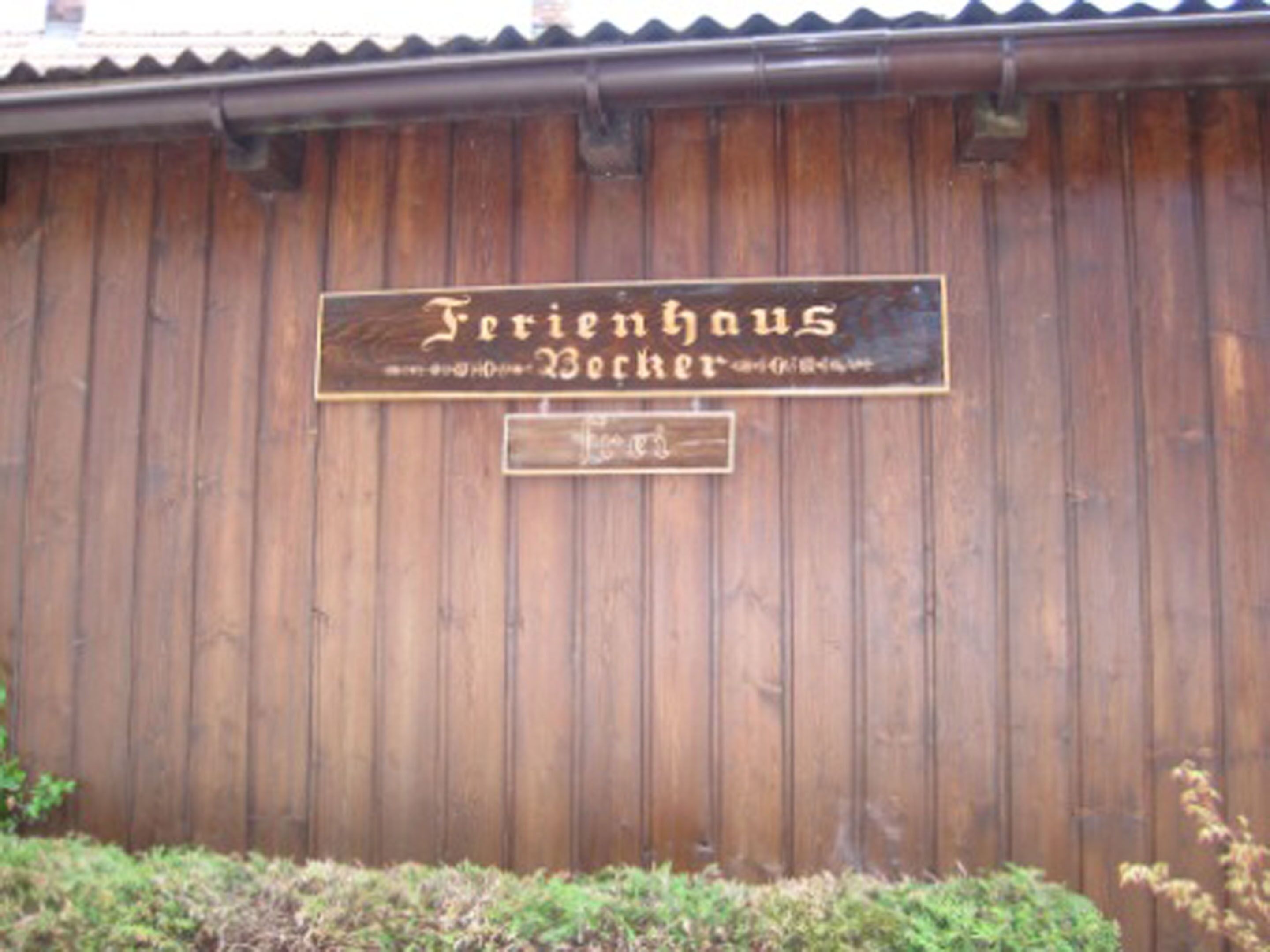 Pared de madera con un letrero que dice 'Ferienhaus Becker'.
