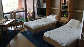A bedroom with two single beds, a desk with a chair, a television, and a wardrobe. - Apartment at the harbor, Germany (Lübeck)