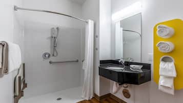 A modern bathroom with a shower, a sink, and a mirror.