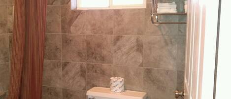 Un baño con inodoro, bañera y cortina de ducha.