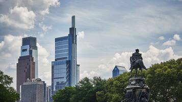 A cityscape with modern skyscrapers and a statue in the foreground.