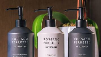 Trois produits de la marque Rossano Ferretti : un gel douche, un shampooing et un après-shampooing.