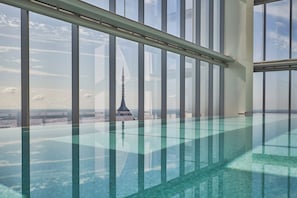 Una piscina interior moderna con vistas despejadas a una torre alta al fondo.