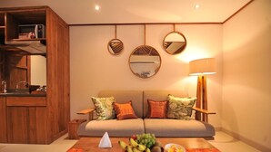 Een gezellige woonkamer met een bank, een houten kast en een fruitschaal op een tafel.