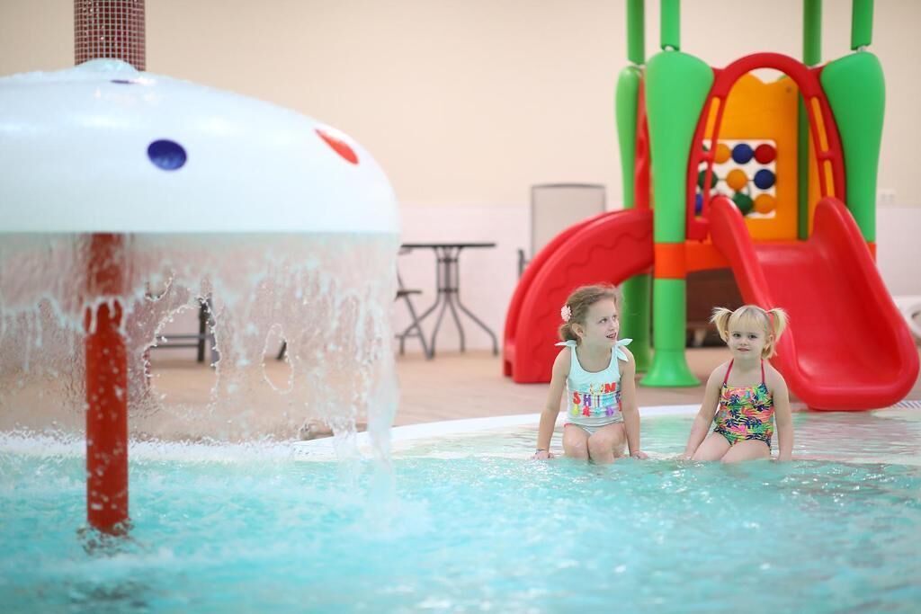 A pool area with a water feature and a children's play structure.