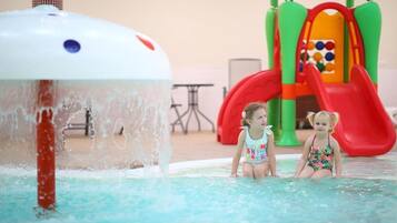 A pool area with a water feature and a children's play structure.