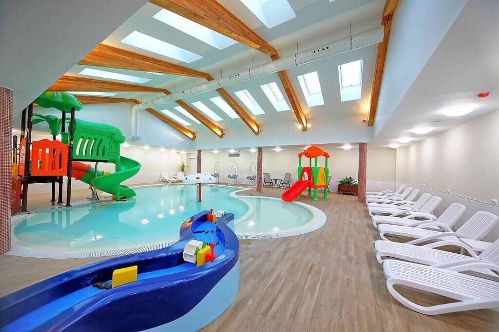 Una piscina interior con toboganes y sillas de descanso.