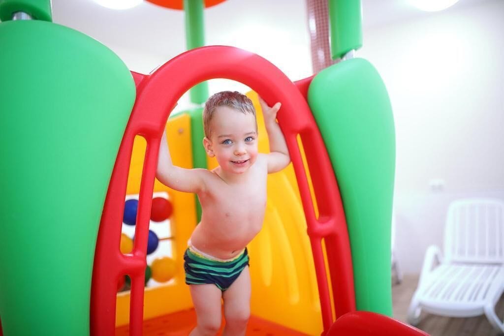 A child playing on a colorful playground structure.