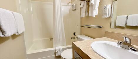 A bathroom with a bathtub, toilet, and sink.
