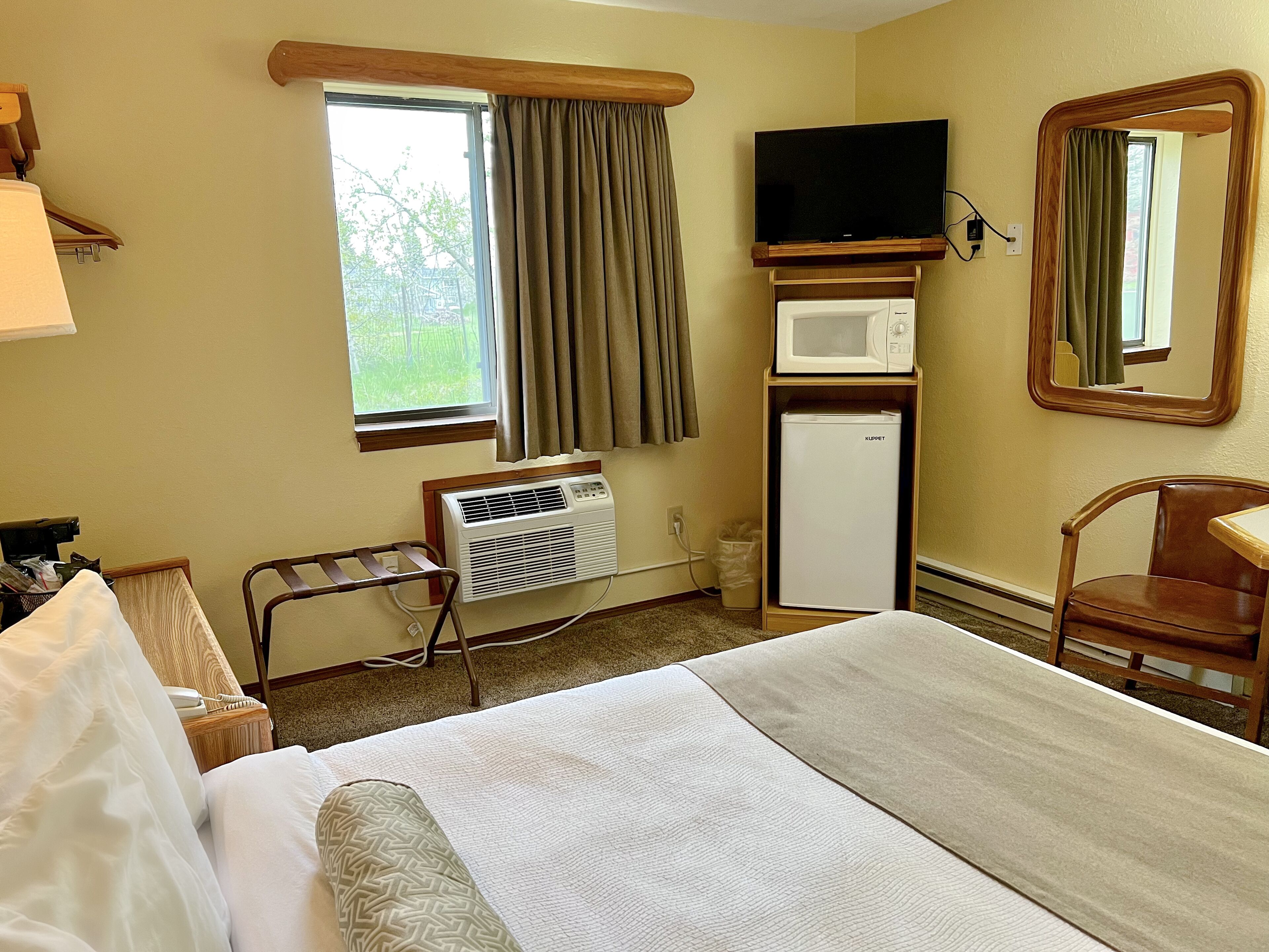 Une chambre d’hôtel équipée d’un lit, d’une télévision, d’un four à micro-ondes et d’un réfrigérateur.