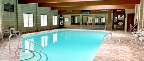 An indoor swimming pool with tiled walls and a wooden ceiling.