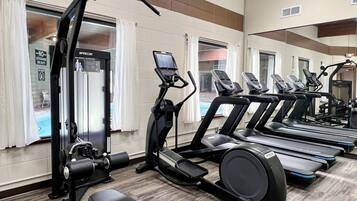 A gym with treadmills, elliptical machines, and weightlifting equipment.
