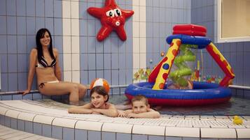 A swimming pool area with a starfish decoration, a children's inflatable play structure, and tiled walls.