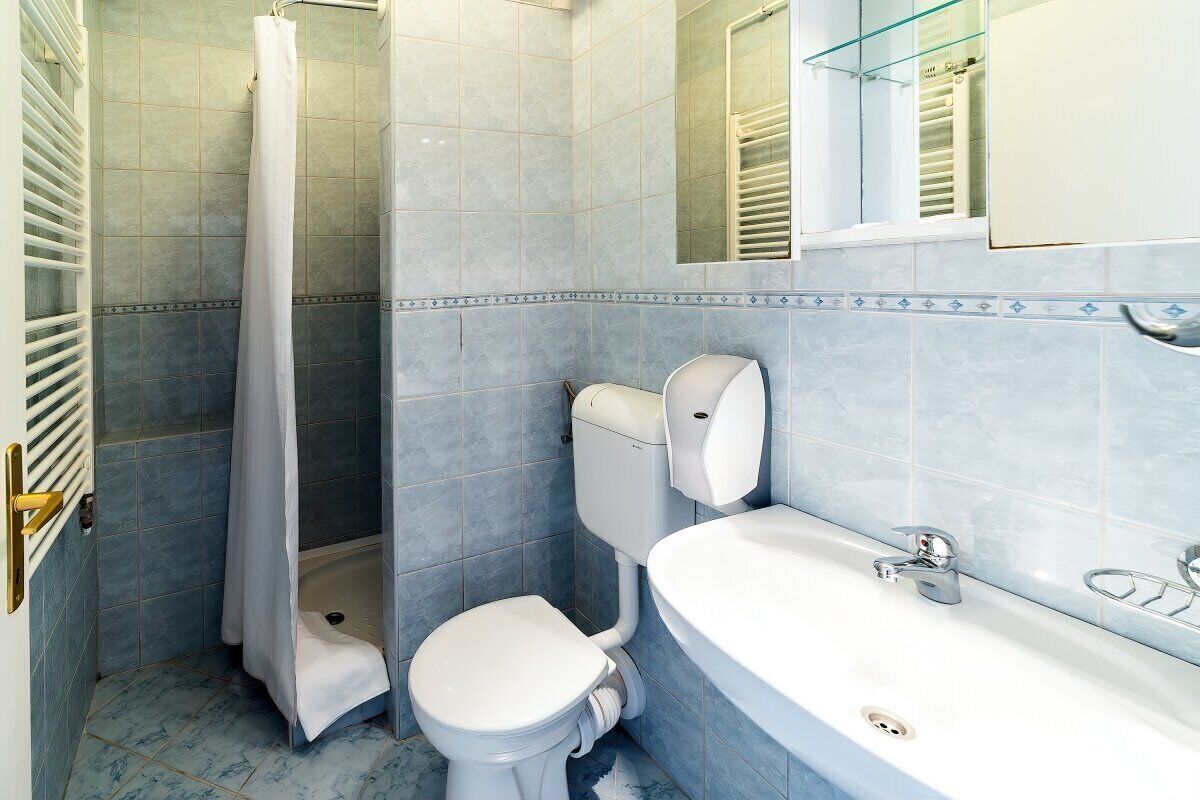 A bathroom with a shower, toilet, and sink.