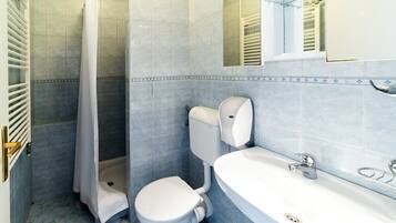 A bathroom with a shower, toilet, and sink.