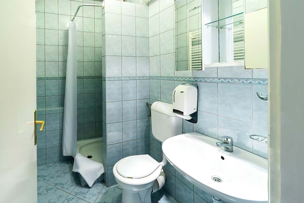A bathroom with a toilet, sink, and shower.