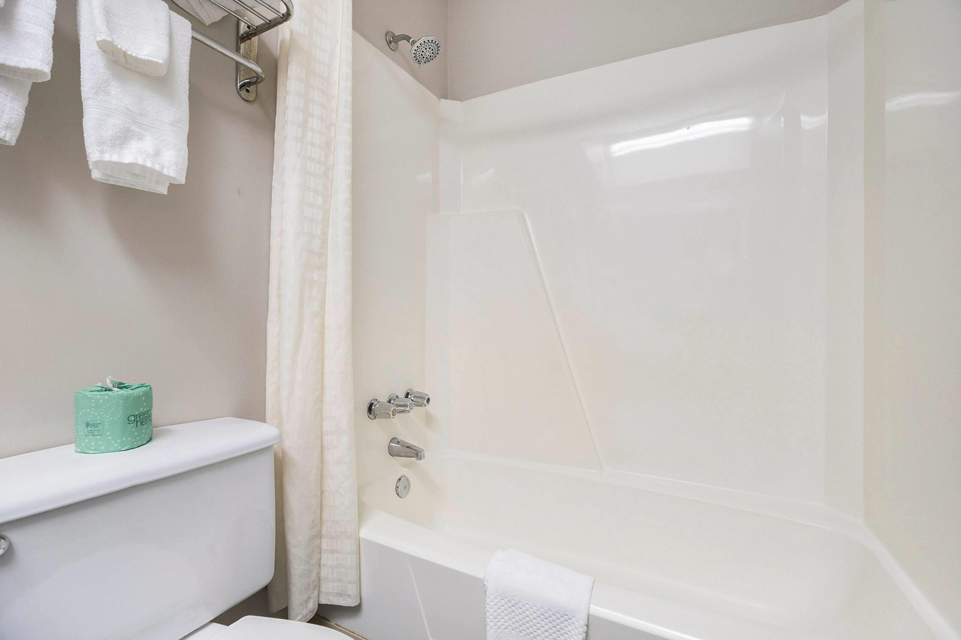 Un baño con bañera, inodoro y perchero para toallas.