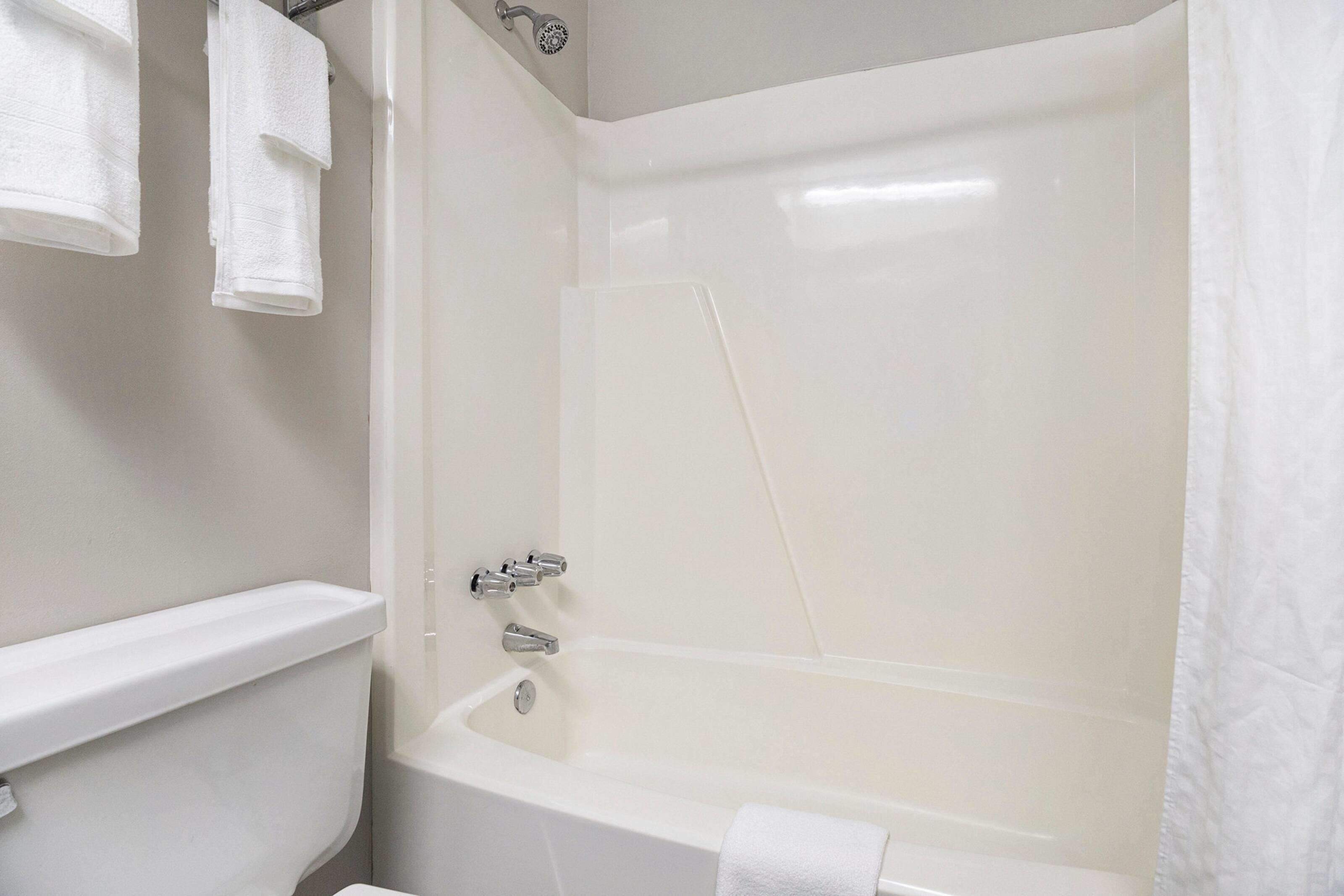 Un baño con bañera, inodoro y cortina de ducha.