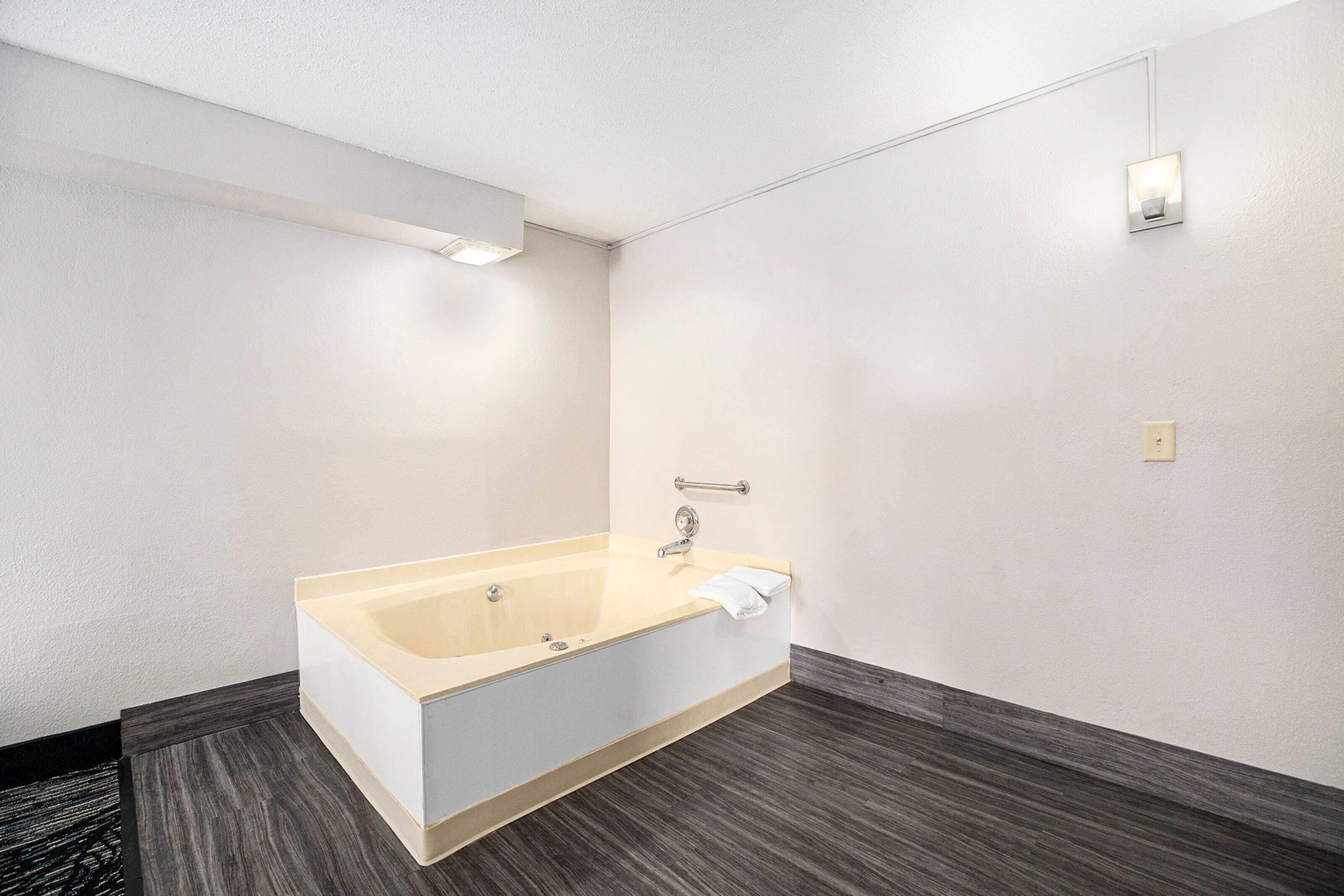 A modern bathroom with a freestanding bathtub, a towel rack, and a wall-mounted light fixture.