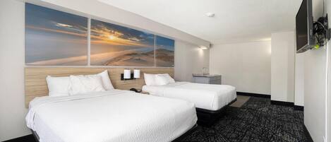 A hotel room with two beds, a large wall mural, a flat-screen TV, and a modern carpet.