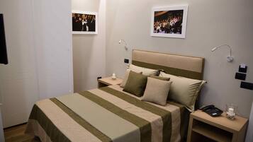 A neatly arranged bedroom with a bed, bedside tables, and a nightstand.