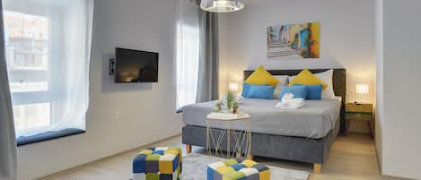 A modern bedroom with a bed, bedside table, and a view of the city.