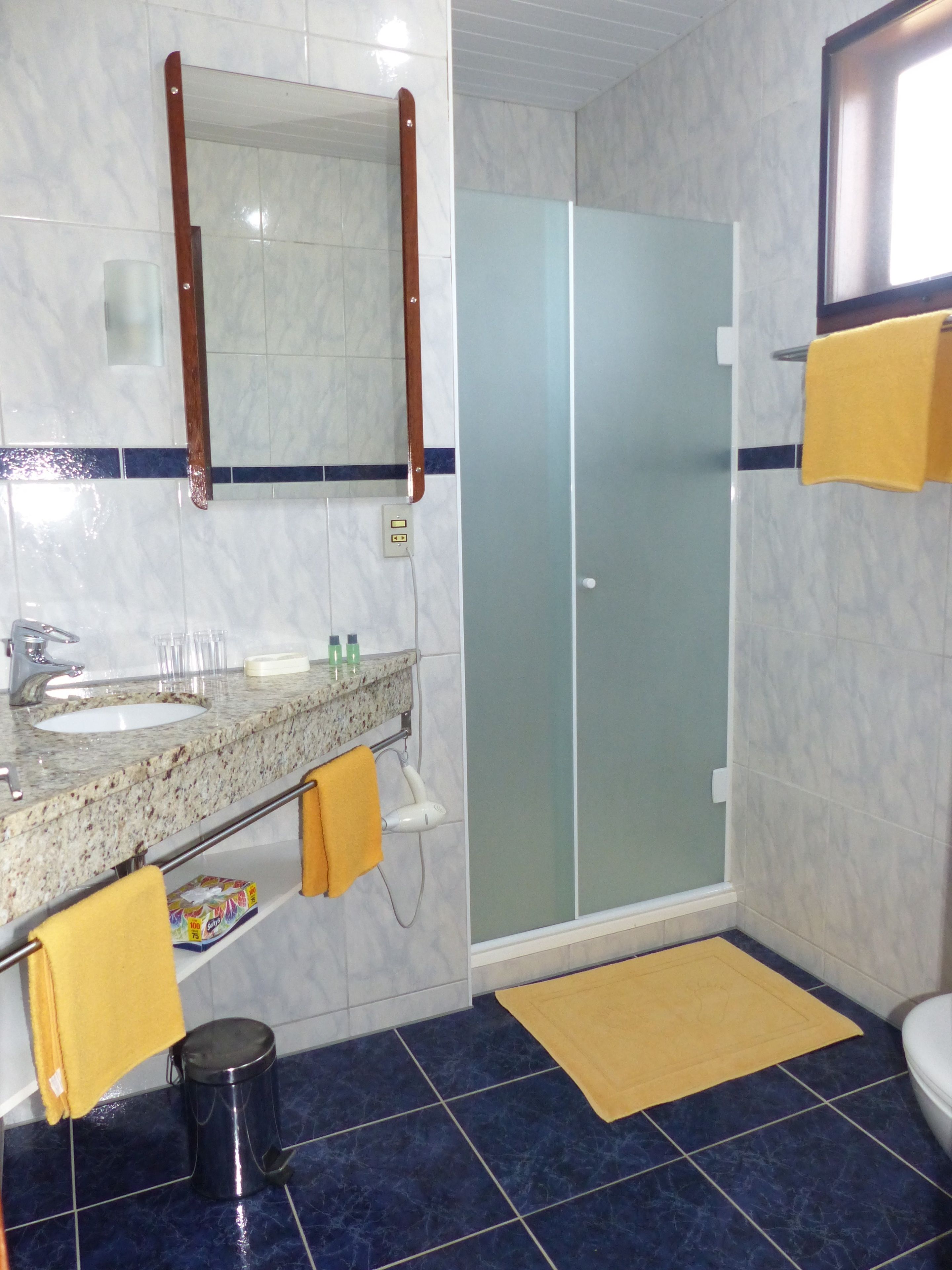 Een badkamer met een wastafel, spiegel en toilet.