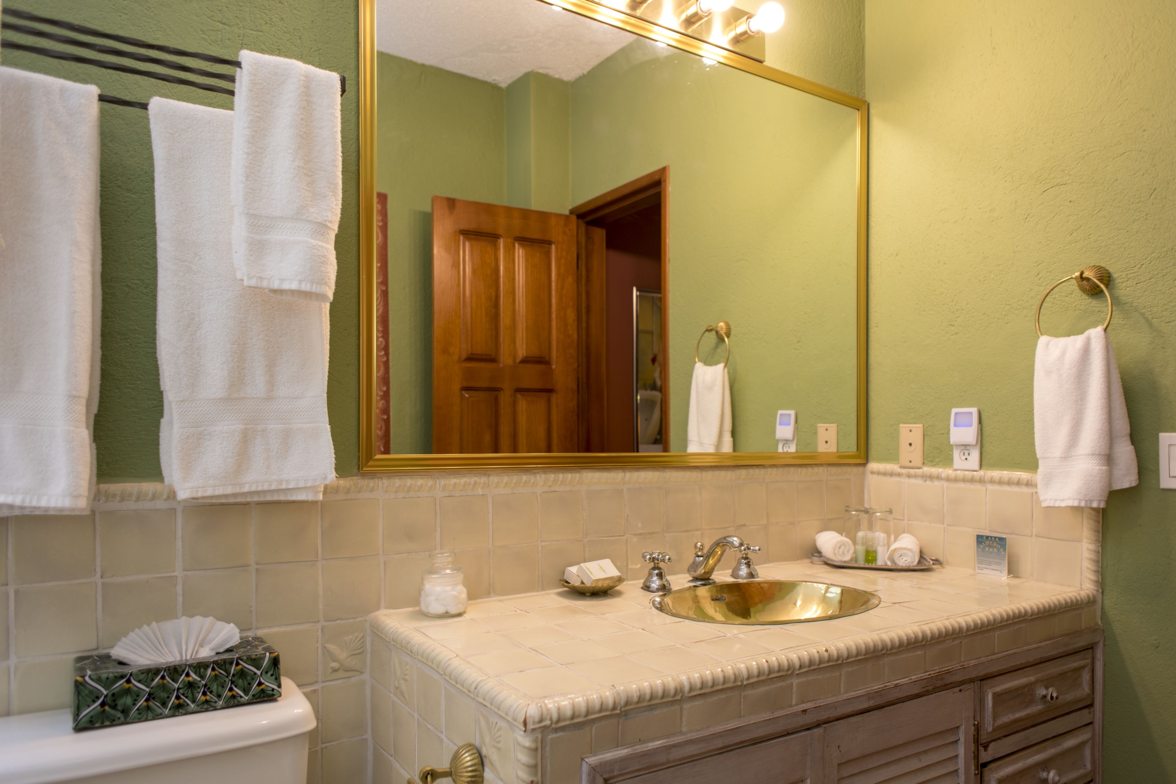 A bathroom with a sink, mirror, and towels.